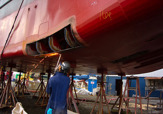 Series showing paint remediation from lead and asbestos on welding hull of Coast Guard cutter, boat yard Hampton VA