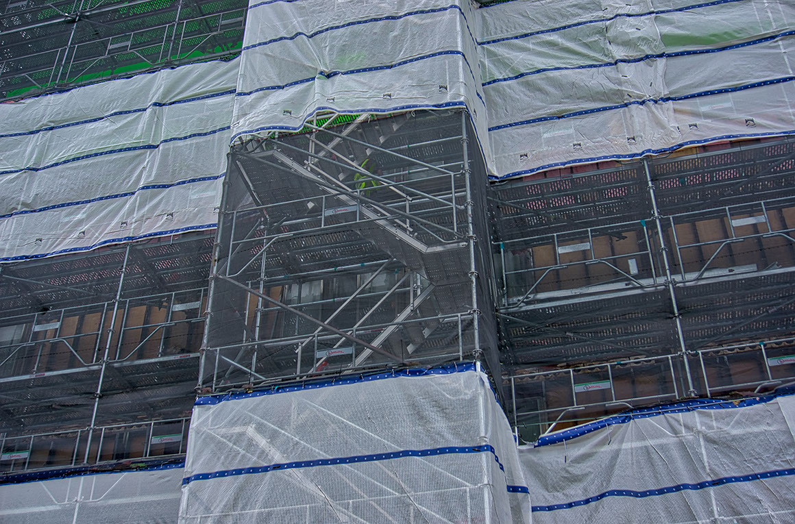 Closeup photo showing scaffolding structure behind safety screen in select demolition of Ivy Tower, Hampton VA